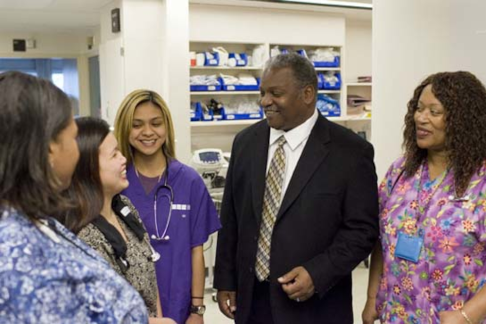 Swanson conferring with a group of nurses in a hospital clinic